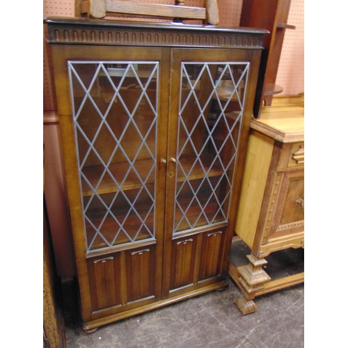 354 - Reproduction oak side cabinet, pair of leaded glazed doors, shelf lined interior above linen fold de... 