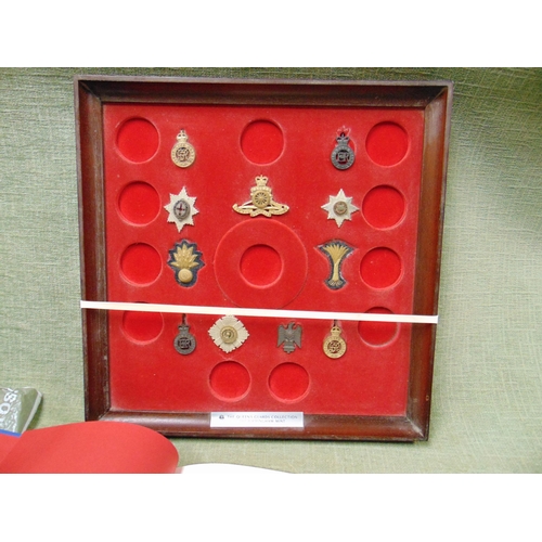 367 - Framed collection of Queen's Guards badges with associated book.