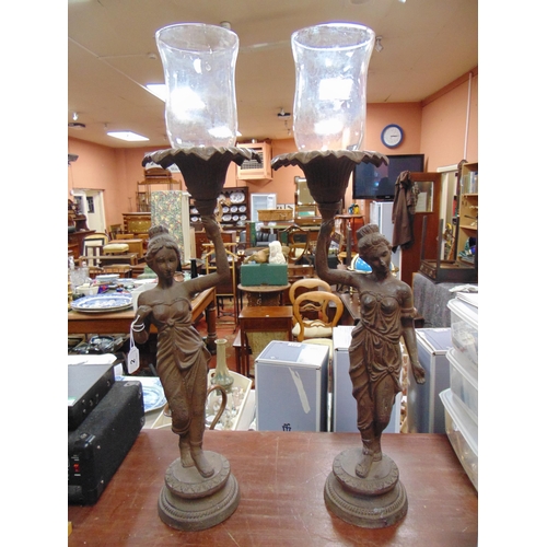 2 - Pair of cast iron candleholders modelled as Roman ladies holding torches aloft, 24.5