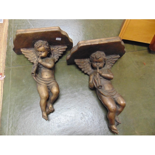 251 - Pair of painted cherub form wall shelves.