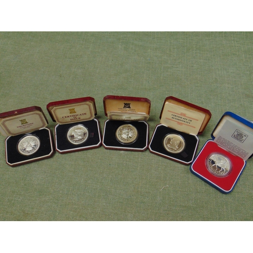 151 - Four cased Pobjoy mint commemorative crowns and one other (5).