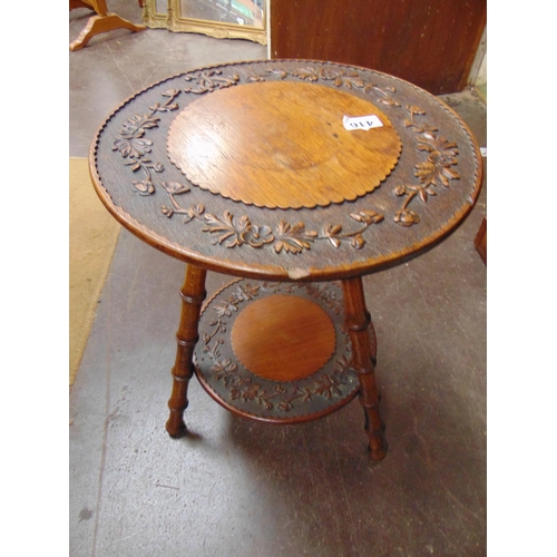 416 - An oak two tier occasional table, having carved leaf decoration and on bamboo form supports. 19