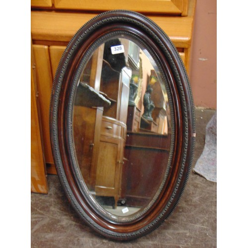 328 - An oval mahogany wall mirror.