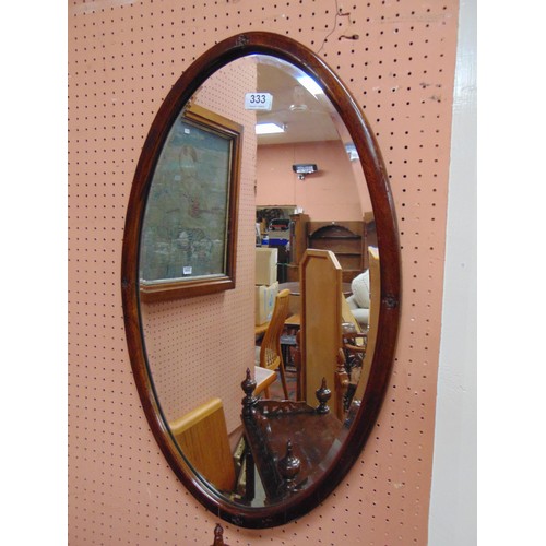 333 - Mahogany oval framed bevel edged wall mirror.