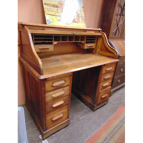 336 - An oak roll top desk, tambour front revealing a fitted interior, with drawers to either side. 46 x 4... 