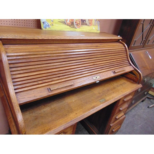 336 - An oak roll top desk, tambour front revealing a fitted interior, with drawers to either side. 46 x 4... 