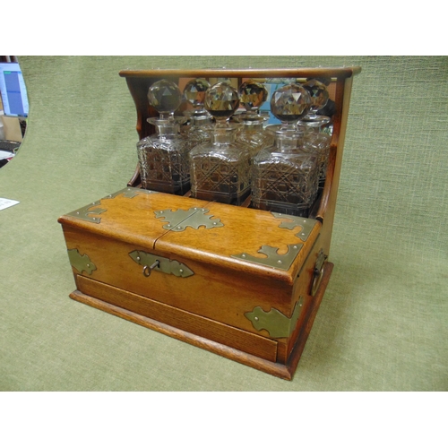 30 - Good late 19th century oak cased Tantalus, having plated mounts, three cut glass decanters, pair of ... 