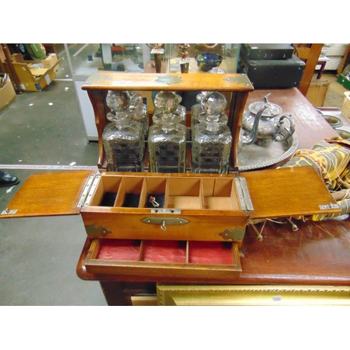 30 - Good late 19th century oak cased Tantalus, having plated mounts, three cut glass decanters, pair of ... 