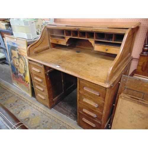 337 - An oak roll top desk, tambour front, revealing a fitted interior, central drawer and further four dr... 