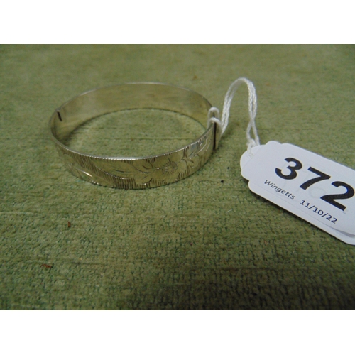 372 - Silver bangle, having engraved floral decoration.