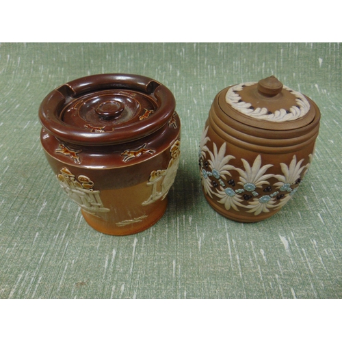 42 - Doulton Lambeth tobacco jar, decorated with windmills, and a similar example. (2).