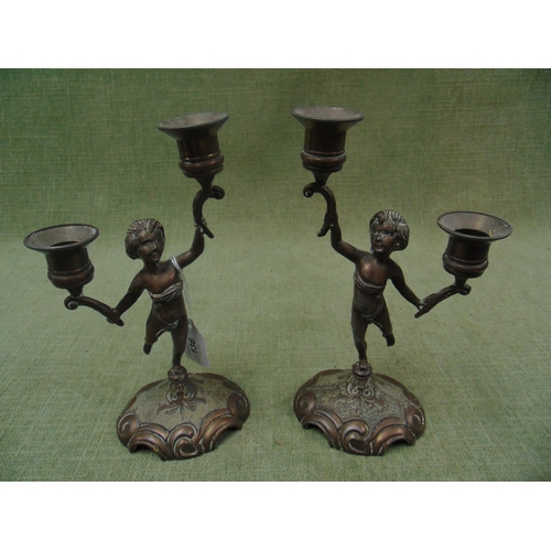 136 - Pair of reproduction cherub form twin division candle holders. Each 9.5