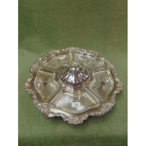 35 - Ornate silver plated lazy Susan, having six glass dishes and moulded decoration.