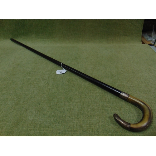 39 - Horn handled walking cane, having silver mounts.