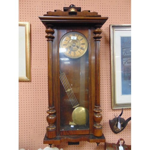 87 - Antique wall clock, having Roman numerals and visible pendulum.