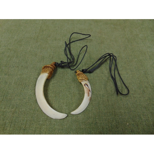 182 - Pair of tusk form reproduction pendants.