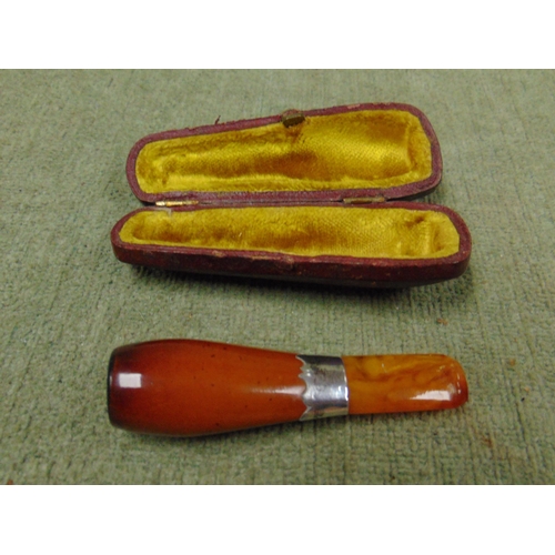 353 - Cased amber coloured cheroot holder, having possibly silver mount.