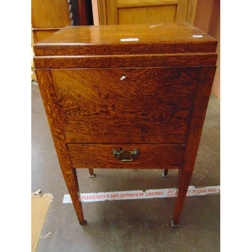 370 - An oak sewing cabinet, fall front over single drawer and on turned frontal supports.