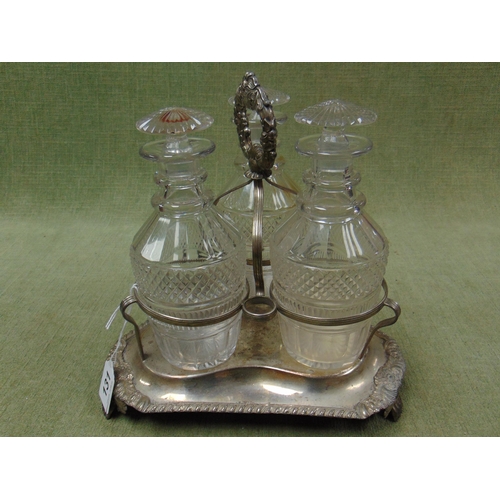 131 - Silver plated three division bottle cruet, having three mallet shaped decanters, and on paw form fee... 