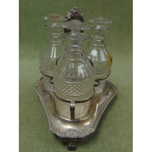 131 - Silver plated three division bottle cruet, having three mallet shaped decanters, and on paw form fee... 