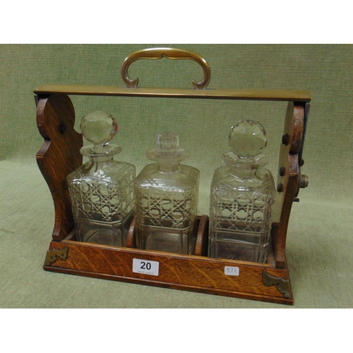 20 - An oak framed three bottle tantalus, 12 x 14 x 5.5