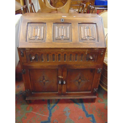 306 - An oak linen fold bureau, fall front revealing a fitted interior, single long drawer, pair of doors ... 