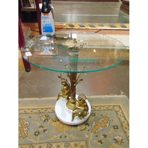 332 - Ornate glass top centre table, the gilt metal base having figural cherub decoration and paw feet. 20... 