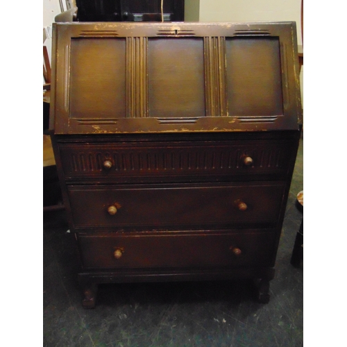 334 - An oak bureau, fall front revealing a fitted interior, three long drawers with knob handles and shor... 