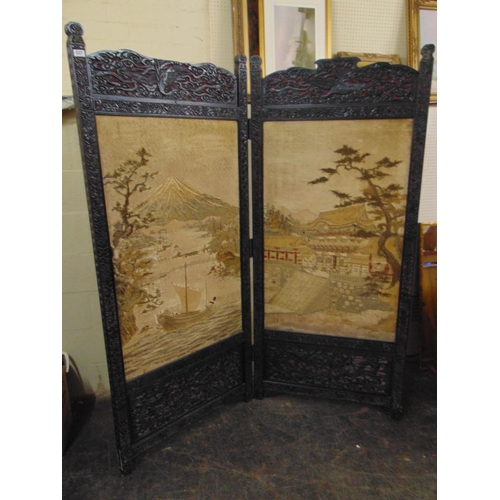 337 - An oriental double fold carved ebony screen, having traditonal silk work decoration.  76 x 56