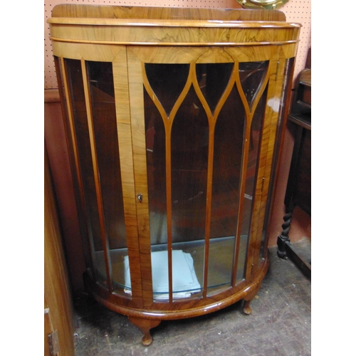 342 - Walnut veneered bow fronted single door display cabinet, shelf lined interior and on short cabriole ... 