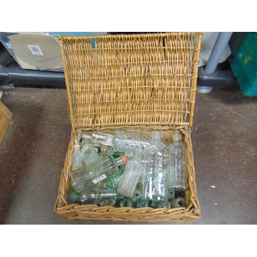 171 - Wicker basket containing a collection of glass bottles.