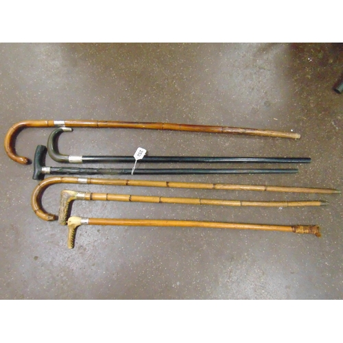 252 - Four silver mounted walking sticks, one other and a riding crop.