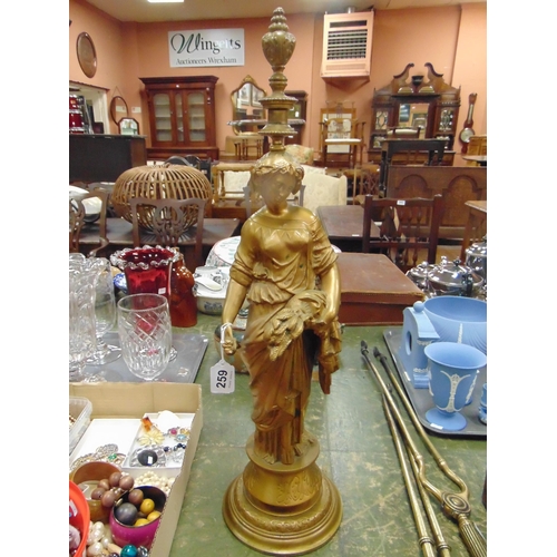 259 - Good antique gilt painted metal figurine, modelled as a woman holding a wheatsheaf. 24