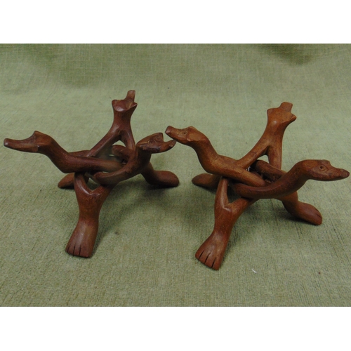 300 - Pair of Eastern hand carved wooden plate stands, of entwined mythical dog form. Each 6