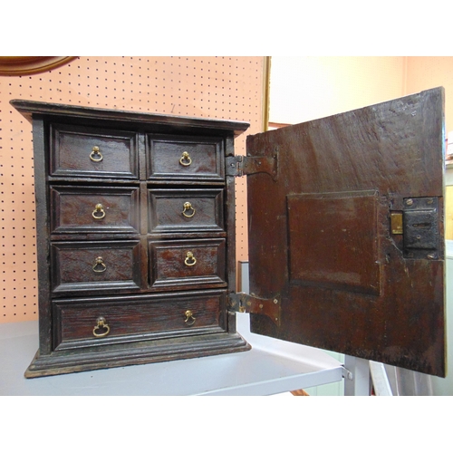 293 - Good antique oak table top cupboard, ogive cornice above single paneled door enclosing  eight short ... 