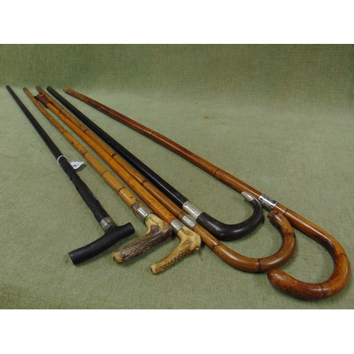 34 - Four silver mounted walking sticks, one other and a riding crop.