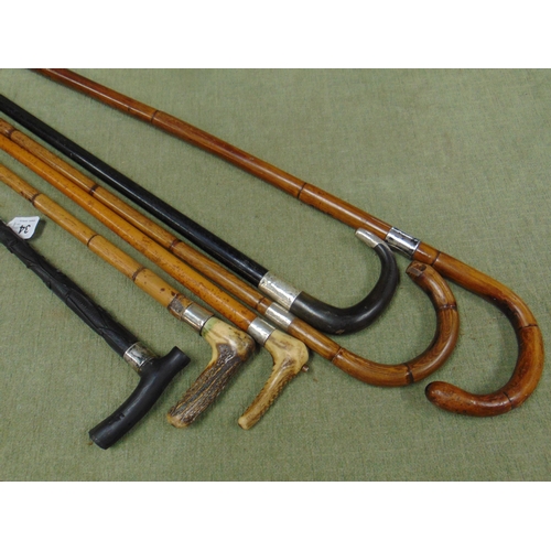 34 - Four silver mounted walking sticks, one other and a riding crop.