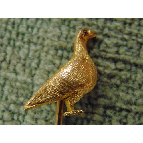 209 - Possibly gold tie pin in the form of a racing pigeon, having ruby stone eye.