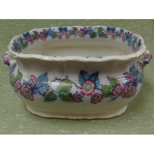 11 - Antique pottery footbath, having floral transfer decoration and side handles.             (sf)