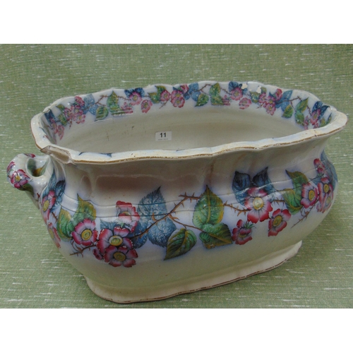 11 - Antique pottery footbath, having floral transfer decoration and side handles.             (sf)