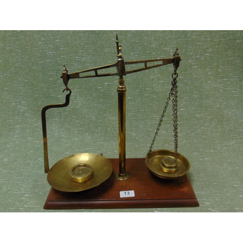 13 - Set of brass scales and weights, set on wooden base.