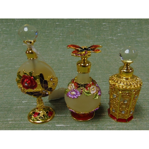 455 - Three enameled scent bottles.