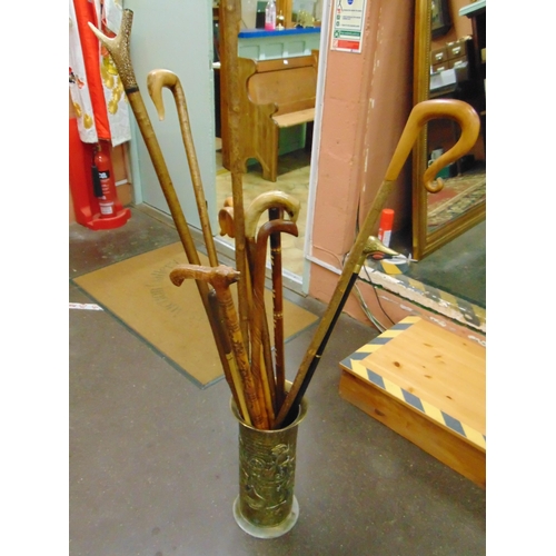 376 - Collection of walking sticks, contained in a brass stick stand.