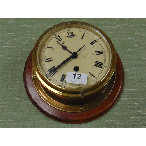 12 - Antique bulkhead clock, having Roman numerals and on wooden mount. 9