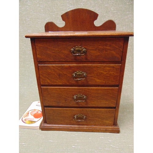 25 - Edwardian oak table top chest, raised back over four drawers with metal handles, containing a collec... 