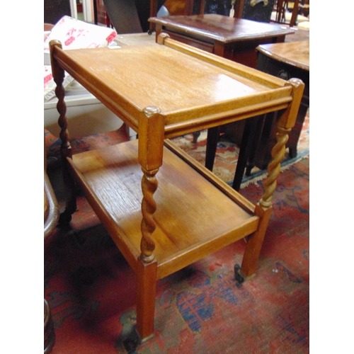 391 - An oak two tier barley twist trolley.