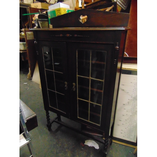 472 - An oak display cabinet, raised back, over pair of leaded glazed doors, enclosing a shelf lined inter... 