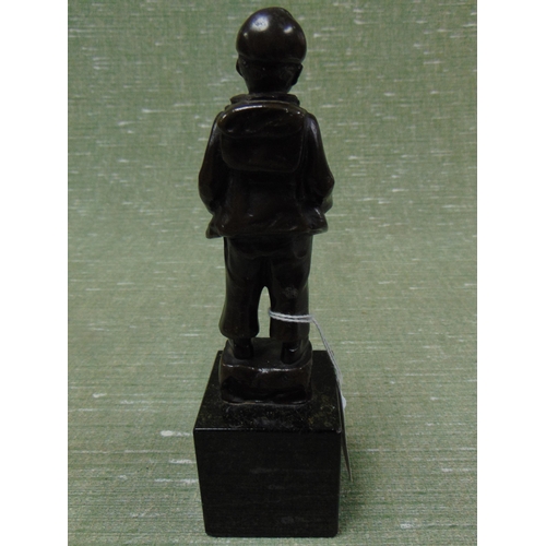 83 - Bronze figure modelled as a young boy with rucksack, on faux marble base, 7