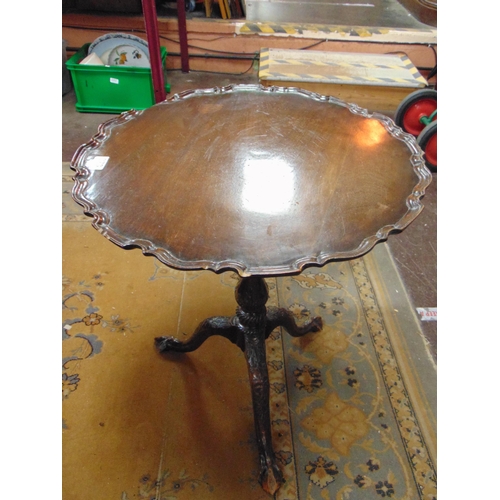 322 - Mahogany tripod table, tilt top with shaped rim, baluster column and on down swept supports. 25