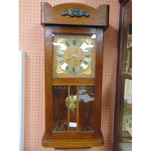 140 - An oak cased wall clock, having Roman numerals.